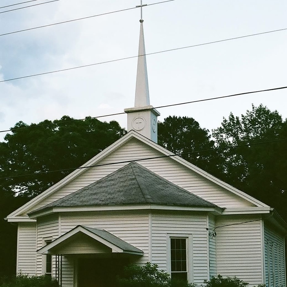 The Portico Church Chapel, a white clapboard chapel with a steeple.